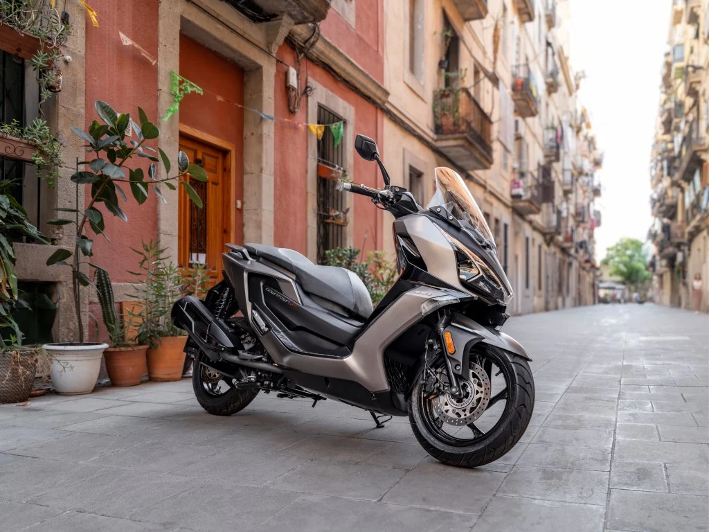 Maxi-scooter KYMCO Downtown GT 350 azul estacionada, destacando seu design moderno, faróis Full LED e rodas de liga leve.