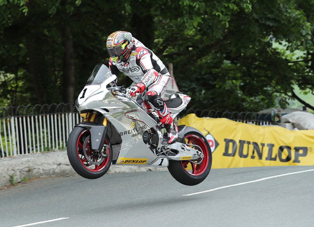 John McGuinness, o 'Morecambe Missile', acelerando sua moto em alta velocidade na Isle of Man TT, mostrando a dedicação e precisão que o tornam uma lenda.