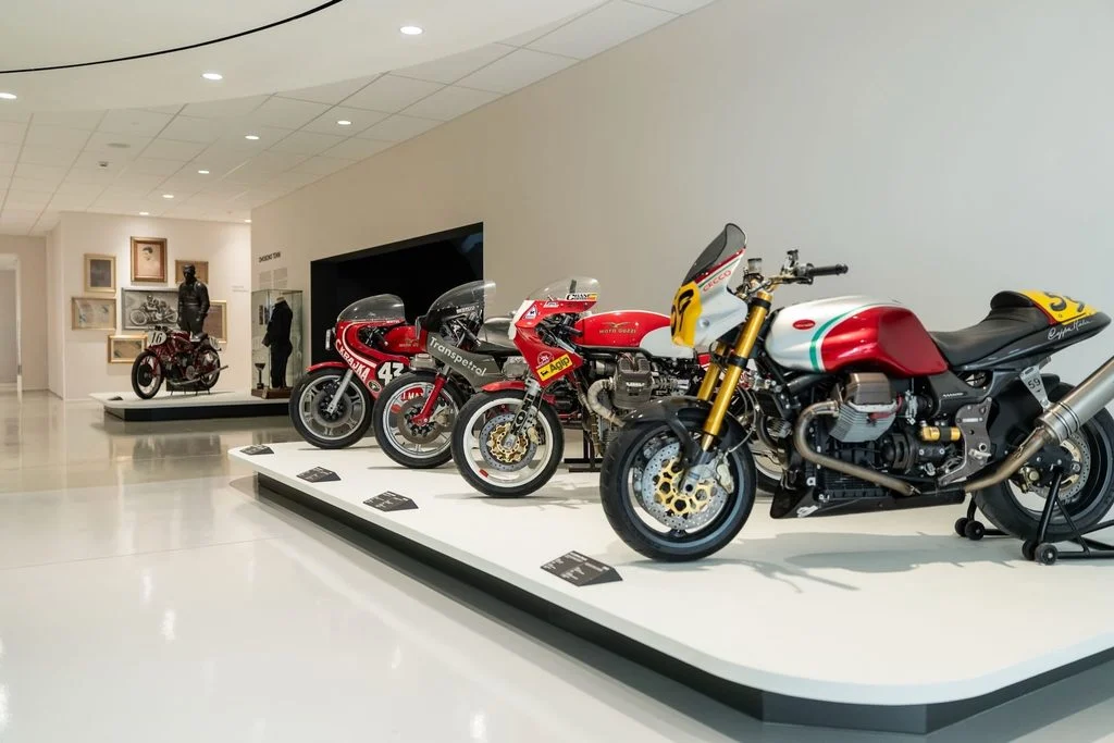 Fachada da nova fábrica Moto Guzzi em Mandello del Lario, com estrutura de vidro e design moderno
