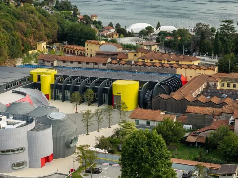 Fachada da nova fábrica Moto Guzzi em Mandello del Lario, com estrutura de vidro e design moderno