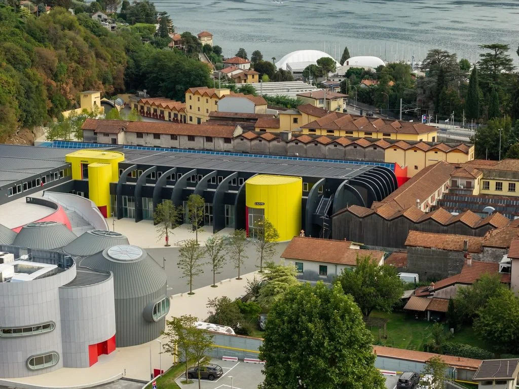 Fachada da nova fábrica Moto Guzzi em Mandello del Lario, com estrutura de vidro e design moderno