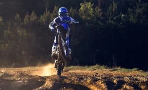 Yamaha YZ250F 2024 em ação em pista de motocross, destacando seu design agressivo e suspensão KYB de alto desempenho.