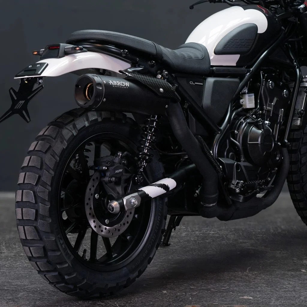 Honda CL500 com escapamento Arrow de fibra de carbono em destaque, realçando seu design scrambler e performance aprimorada em ambiente urbano.