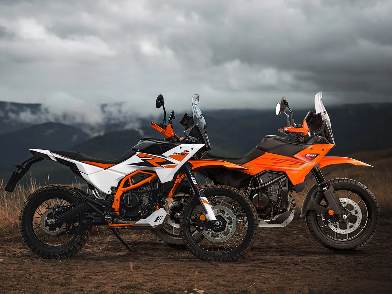 Moto KTM off-road em ação, representando o foco da marca no desempenho fora de estrada, com paisagem montanhosa ao fundo e poeira levantando.