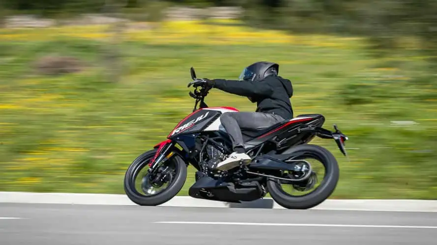 Rieju NKD 125 estacionada, destacando seu design moderno e semelhanças com a KTM 125 Duke, em um ambiente urbano.