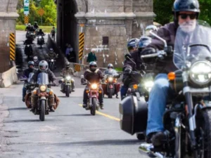 Motociclistas Royal Enfield se preparando para a largada do One Ride 2026 em uma rua ensolarada, com diversas motos alinhadas.