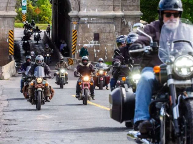 Motociclistas Royal Enfield se preparando para a largada do One Ride 2026 em uma rua ensolarada, com diversas motos alinhadas.