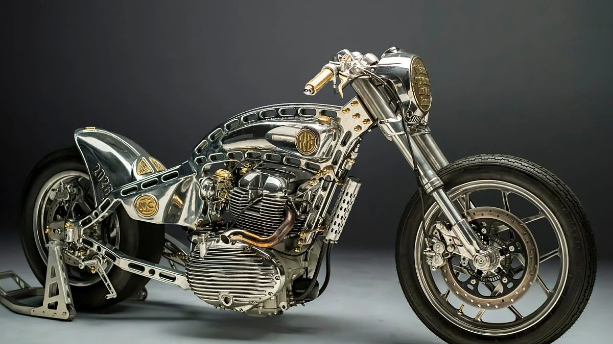 A Royal Enfield Shotgun 650 customizada Shilpa em close-up, uma motocicleta drag racing com chassi hardtail em alumínio e motor 865cc, destacando seu design agressivo e rodas alargadas.