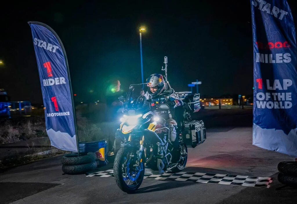 Sam Sunderland posando com sua motocicleta Triumph Tiger 1200 Rally Explorer, preparada para a tentativa de recorde mundial de volta ao mundo.