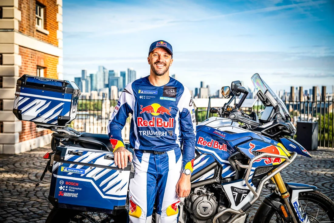 Sam Sunderland posando com sua motocicleta Triumph Tiger 1200 Rally Explorer, preparada para a tentativa de recorde mundial de volta ao mundo.