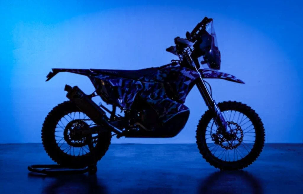 Skyler Howes pilotando a ZXMoto 450 Rally em alta velocidade no deserto, com equipamento de navegação e poeira levantando, em uma cena dinâmica de rally-raid.