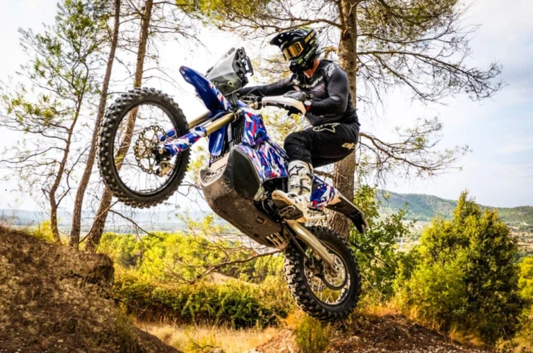 Skyler Howes pilotando a ZXMoto 450 Rally em alta velocidade no deserto, com equipamento de navegação e poeira levantando, em uma cena dinâmica de rally-raid.