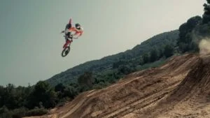Motocicleta elétrica Stark Varg em ação em uma pista de supercross, levantando poeira e demonstrando seu desempenho silencioso e potente.