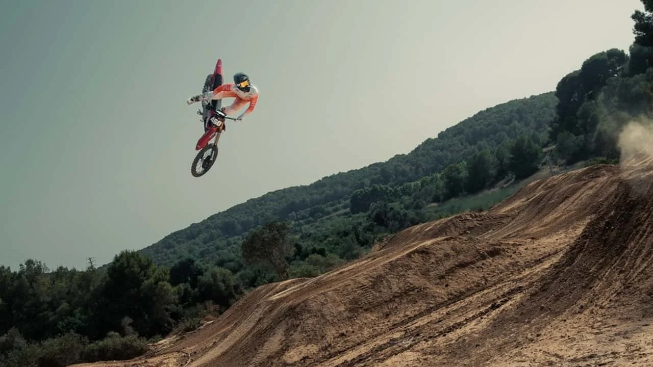 Motocicleta elétrica Stark Varg em ação em uma pista de supercross, levantando poeira e demonstrando seu desempenho silencioso e potente.