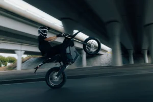 Stark Varg SM Sköll supermoto elétrica de alto desempenho, vista lateralmente em acabamento totalmente preto com detalhes dourados.