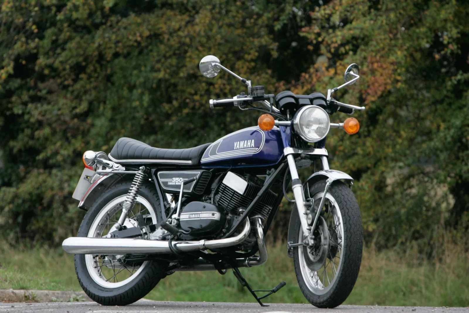 Yamaha RD350 clássica de dois tempos em azul com listras brancas, destacando seu design esportivo e atemporal.