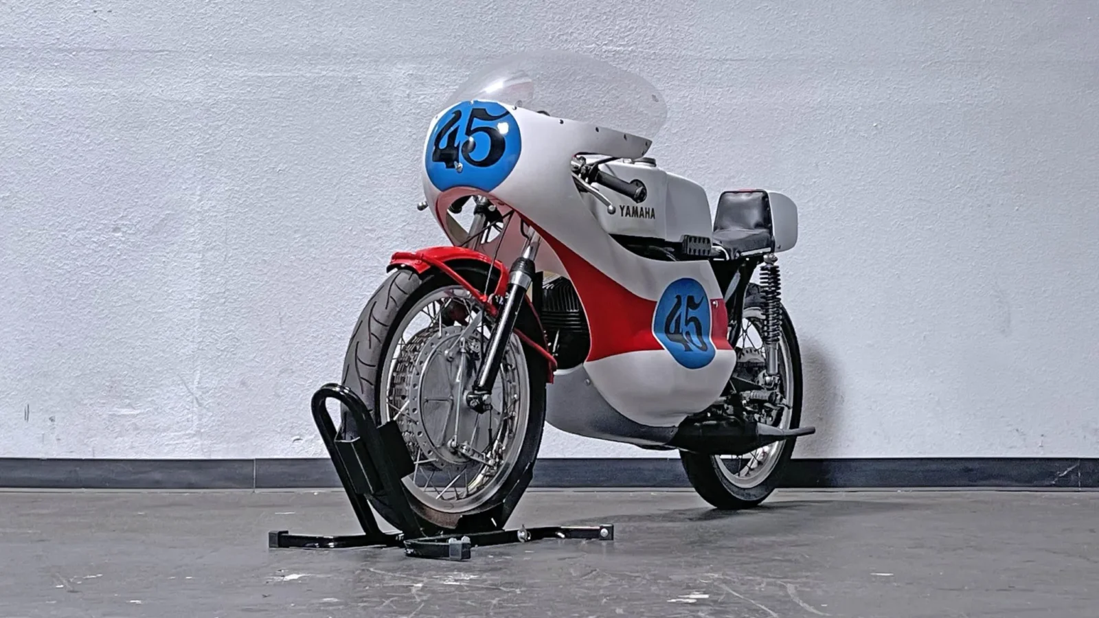 Yamaha RD350 clássica de dois tempos em azul com listras brancas, destacando seu design esportivo e atemporal.