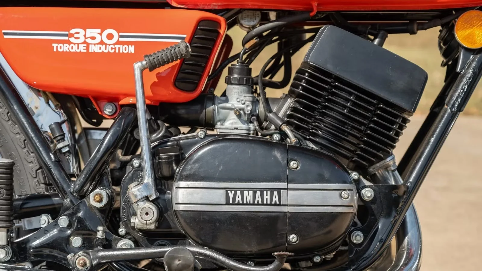 Yamaha RD350 clássica de dois tempos em azul com listras brancas, destacando seu design esportivo e atemporal.