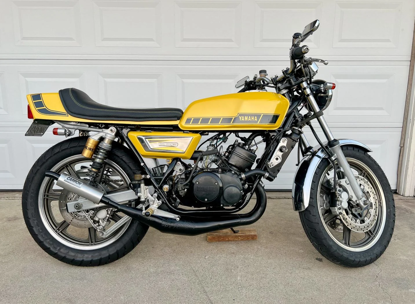 Yamaha RD350 clássica de dois tempos em azul com listras brancas, destacando seu design esportivo e atemporal.