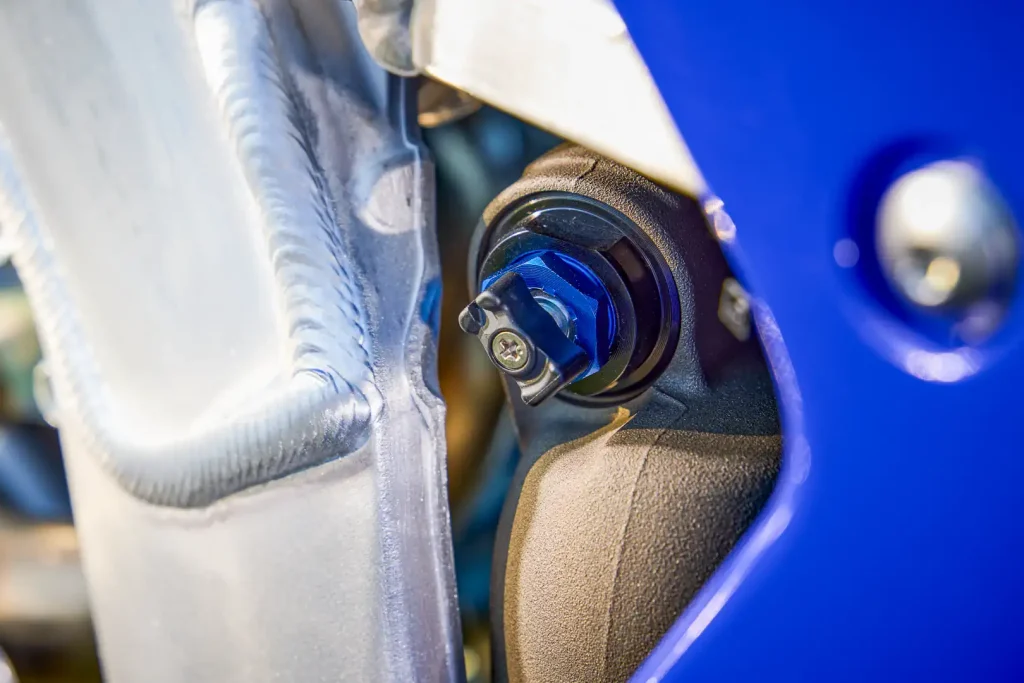 Yamaha WR450F 2027 azul em ação em trilha de terra com suspensão trabalhando