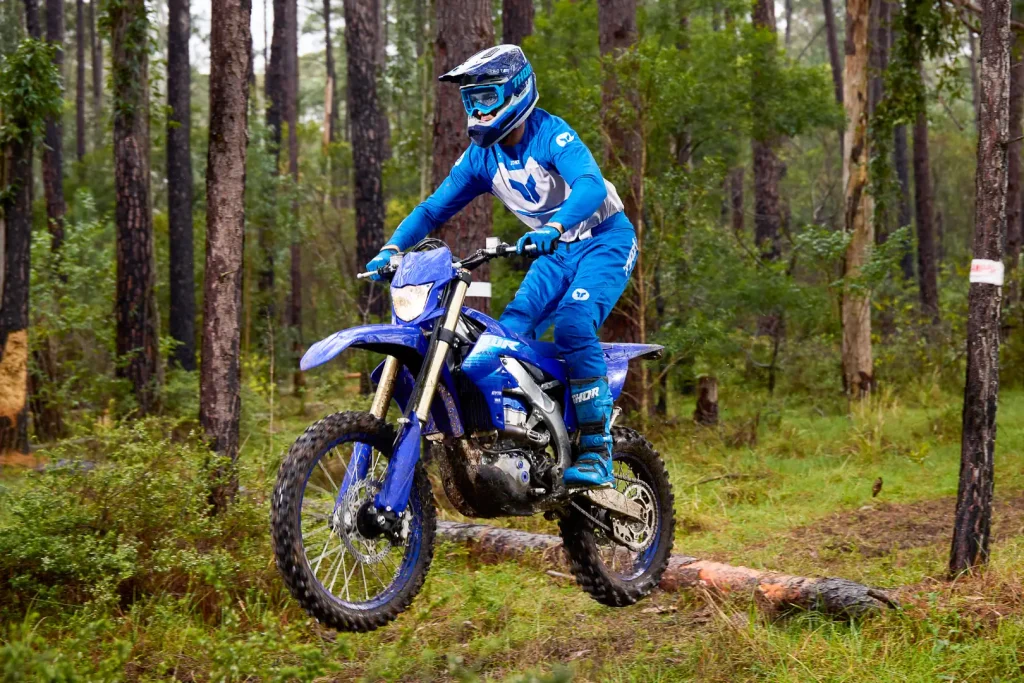 Yamaha WR450F 2027 azul em ação em trilha de terra com suspensão trabalhando