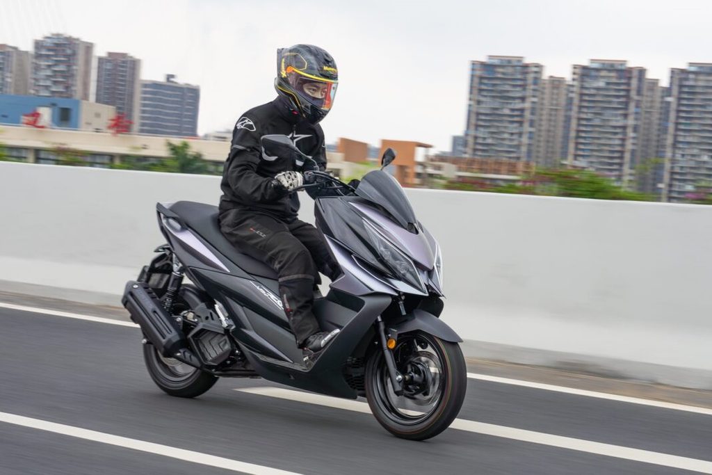 Zontes V125 estacionada em ambiente urbano, exibindo seu design desportivo e moderno, com detalhes tecnológicos visíveis.