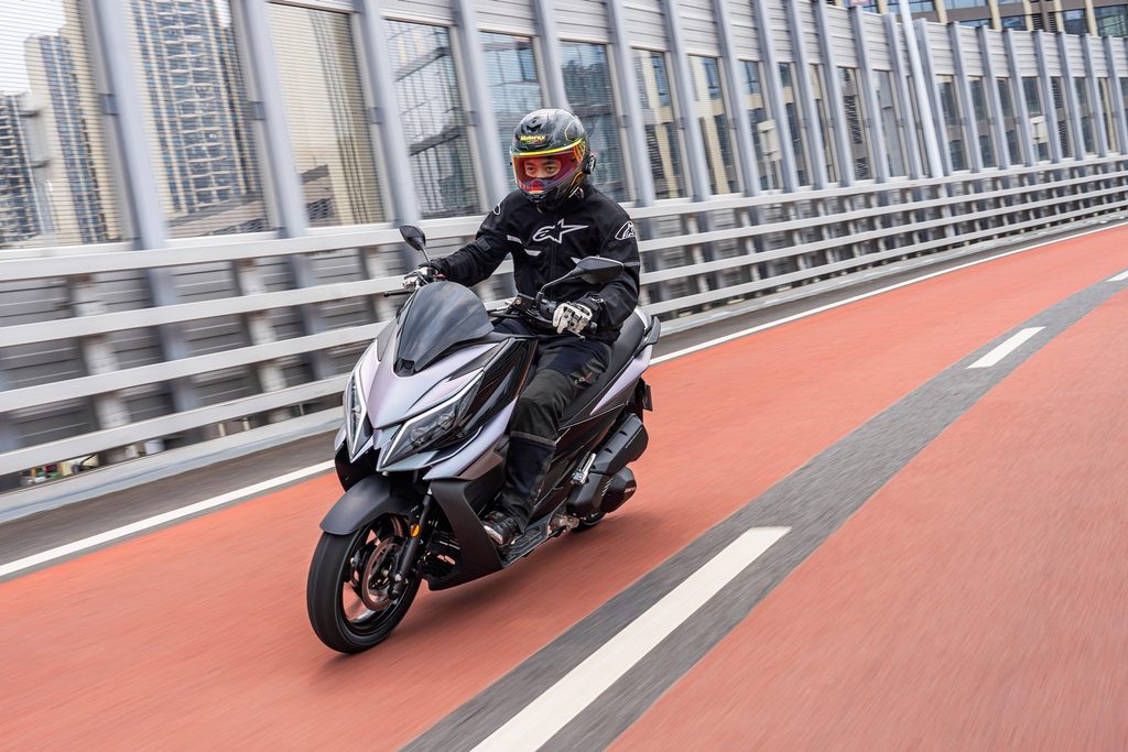 Zontes V125 estacionada em ambiente urbano, exibindo seu design desportivo e moderno, com detalhes tecnológicos visíveis.