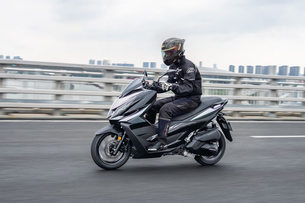 Zontes V125 estacionada em ambiente urbano, exibindo seu design desportivo e moderno, com detalhes tecnológicos visíveis.