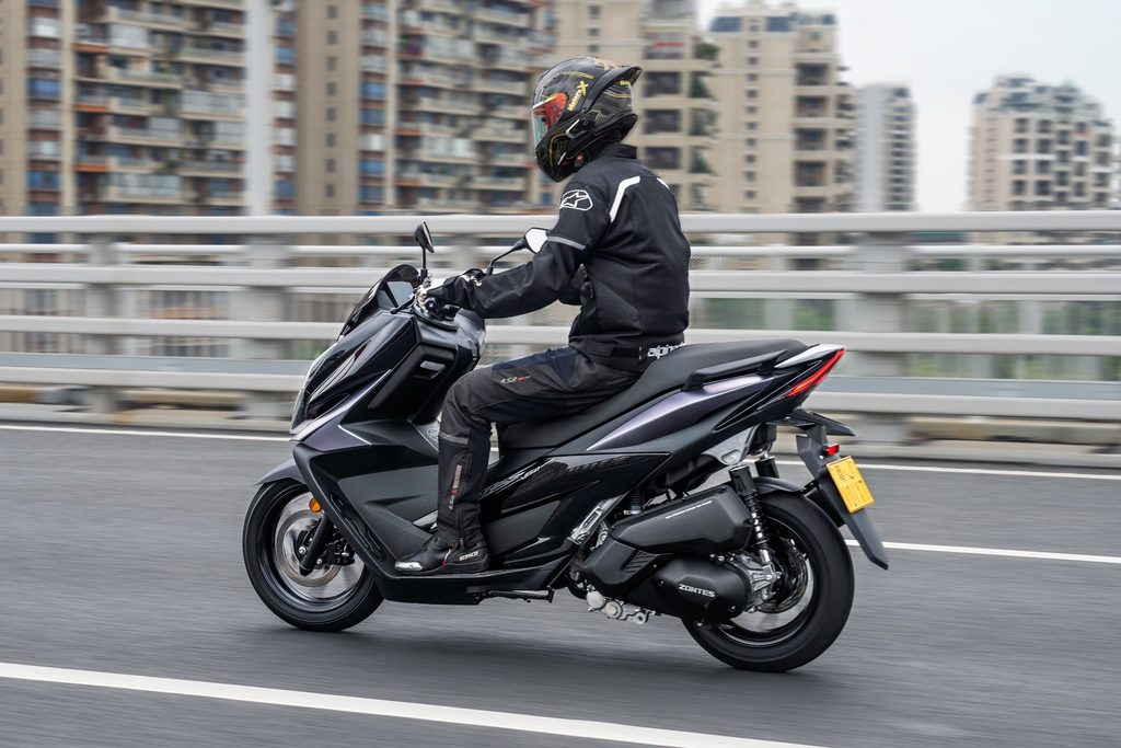 Zontes V125 estacionada em ambiente urbano, exibindo seu design desportivo e moderno, com detalhes tecnológicos visíveis.