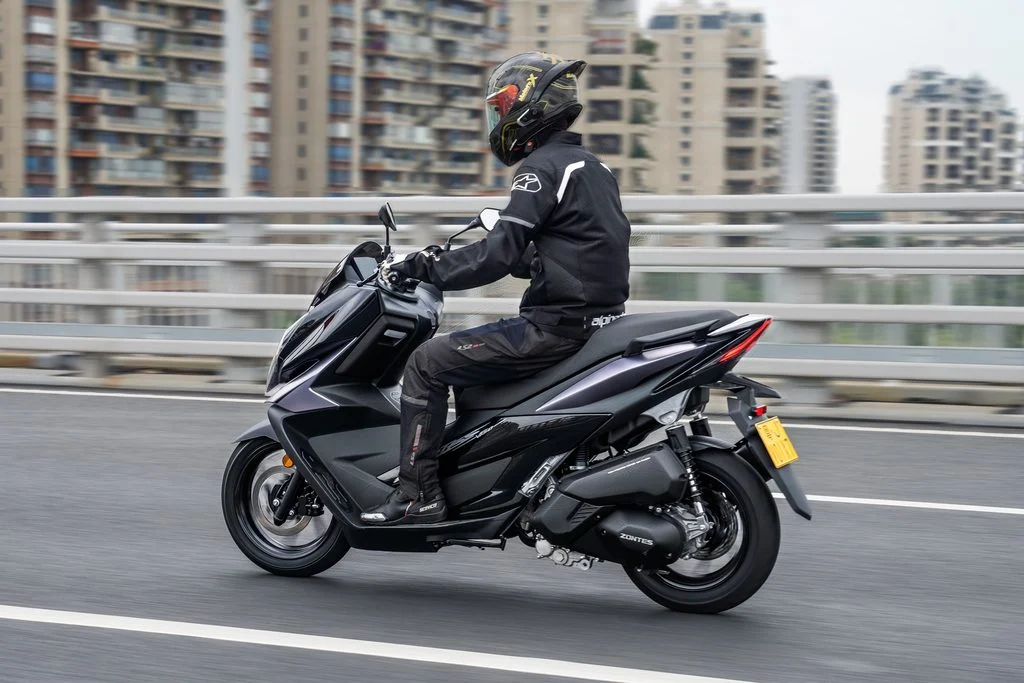 Zontes V125 estacionada em ambiente urbano, exibindo seu design desportivo e moderno, com detalhes tecnológicos visíveis.