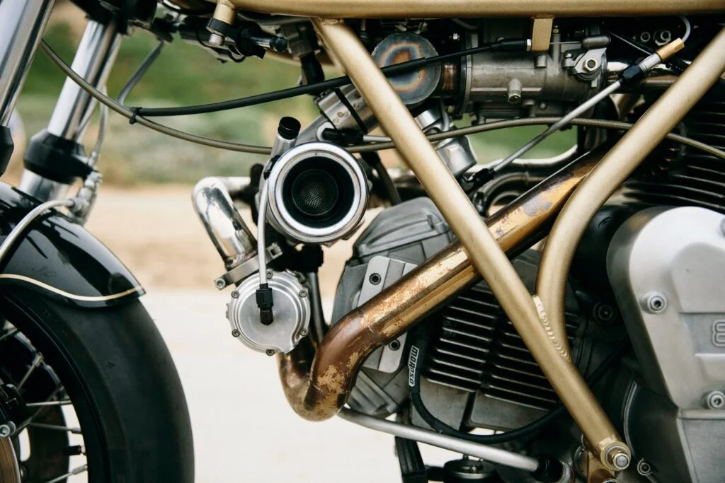 Max Hazan ao lado de sua Ducati 860GT Turbo customizada, com detalhes do motor sobrealimentado visíveis