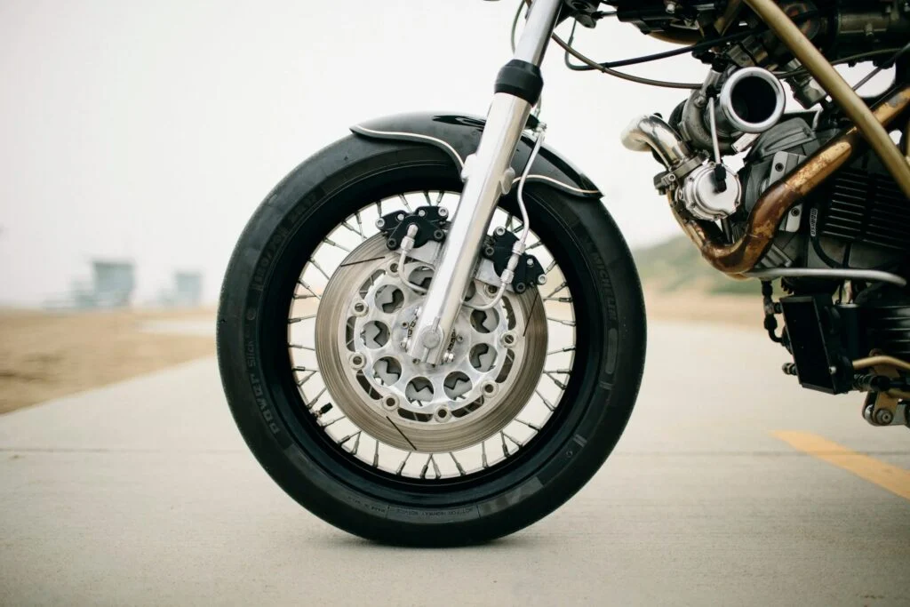 Max Hazan ao lado de sua Ducati 860GT Turbo customizada, com detalhes do motor sobrealimentado visíveis