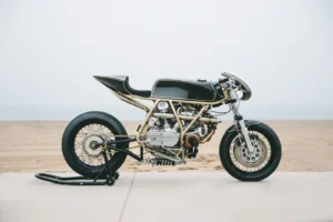 Max Hazan ao lado de sua Ducati 860GT Turbo customizada, com detalhes do motor sobrealimentado visíveis