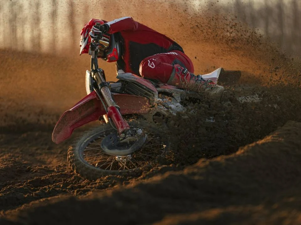 Motocicleta Ducati Desmo450 MX em ação na pista de motocross, destacando seu design agressivo e componentes de alta performance.