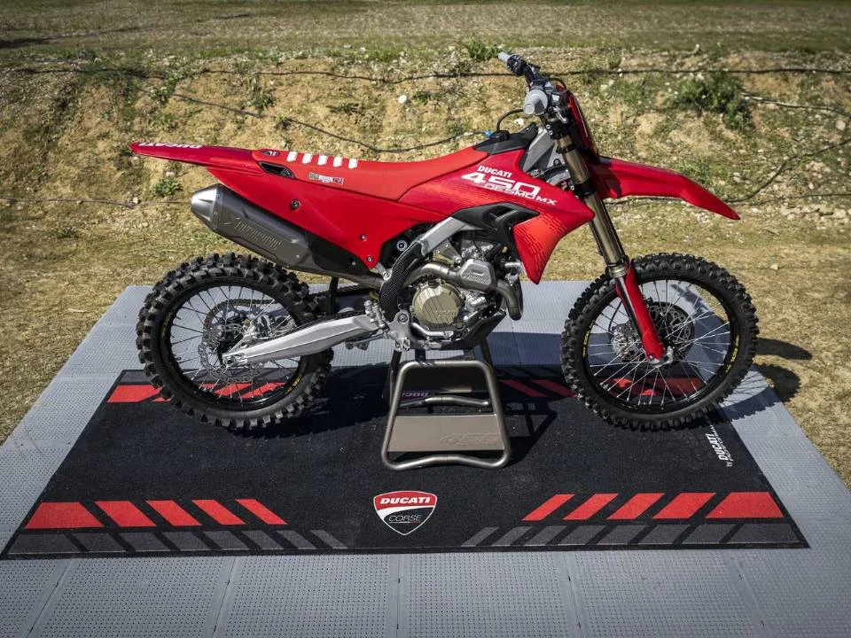 Motocicleta Ducati Desmo450 MX em ação na pista de motocross, destacando seu design agressivo e componentes de alta performance.