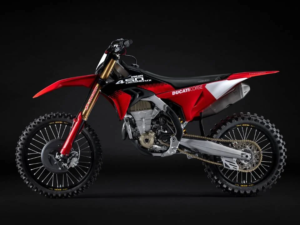 Motocicleta Ducati Desmo450 MX em ação na pista de motocross, destacando seu design agressivo e componentes de alta performance.