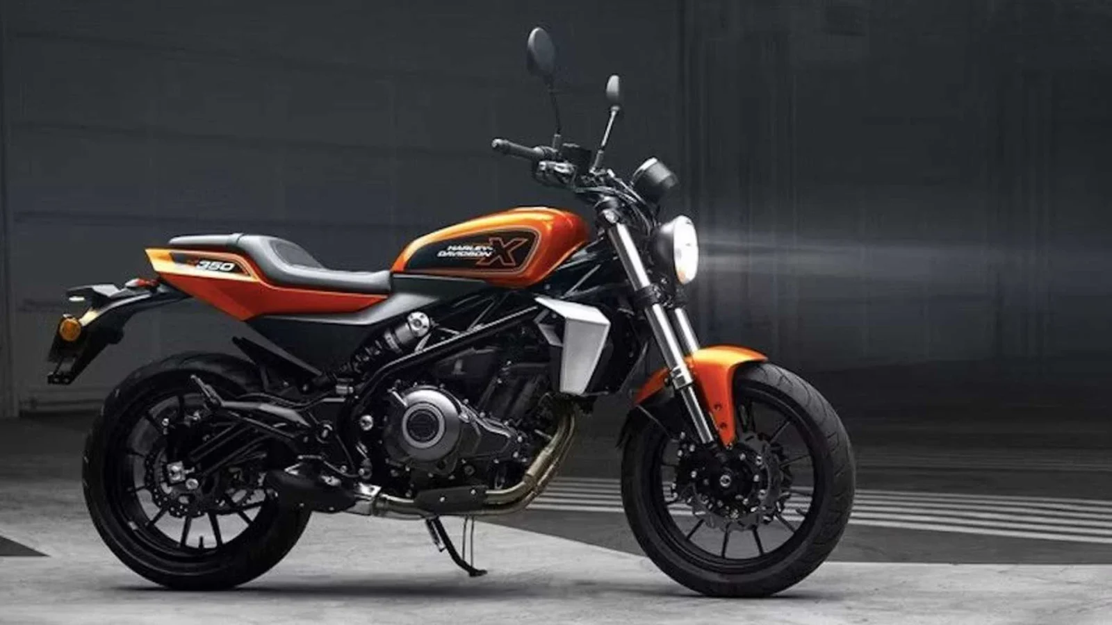 Uma Harley-Davidson X350 em cor laranja e uma Harley-Davidson X500 em cinza metálico, estacionadas lado a lado em um ambiente urbano asiático, destacando seus designs de estilo tracker e componentes modernos.