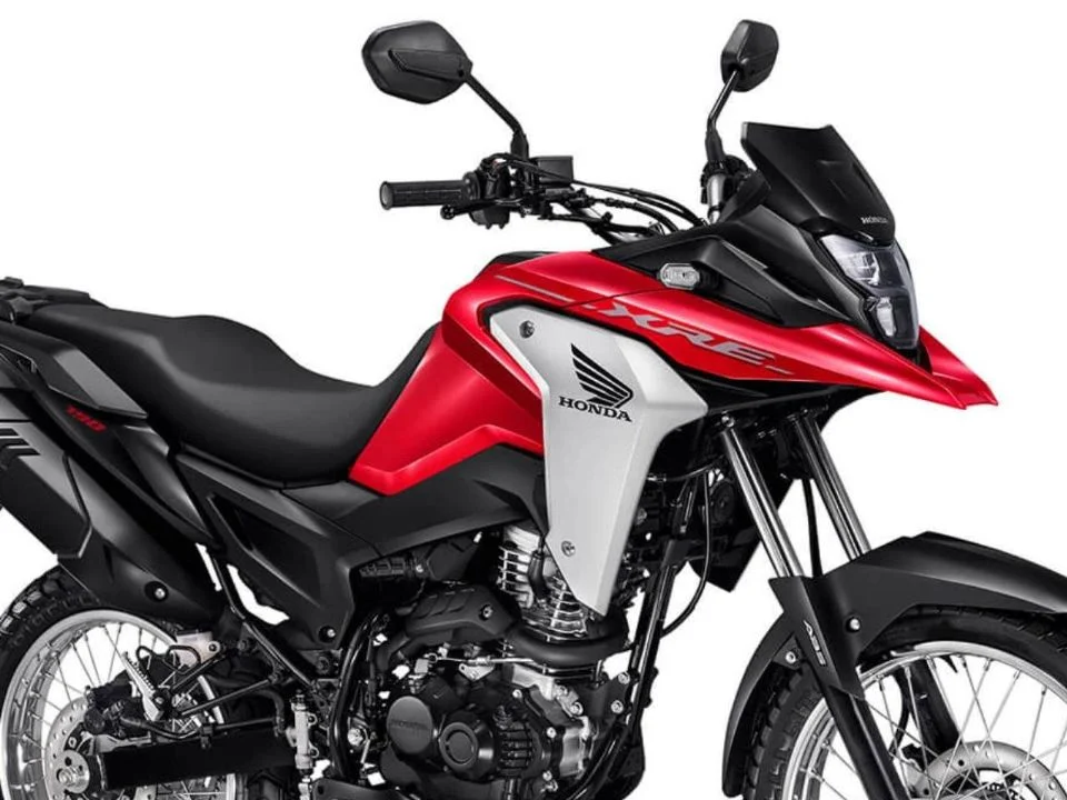 Honda XRE 190 2026 cinza metálico estacionada, exibindo o design atualizado com bico alongado e iluminação LED, destacando sua proposta trail.