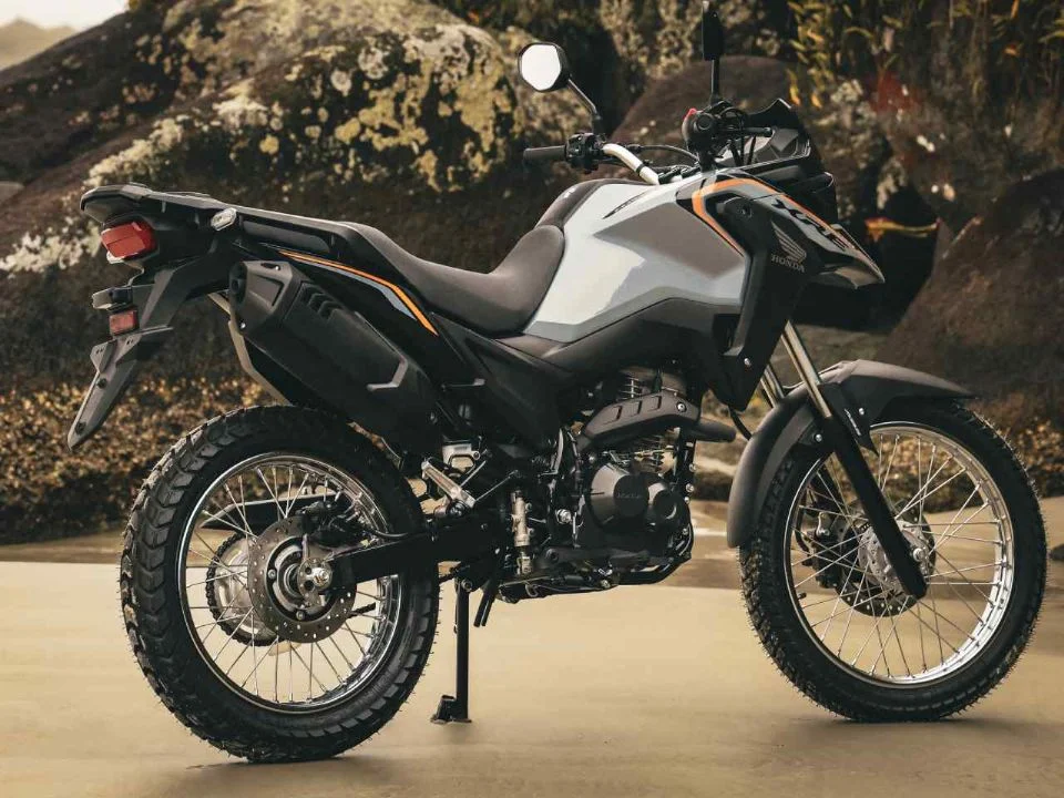 Honda XRE 190 2026 cinza metálico estacionada, exibindo o design atualizado com bico alongado e iluminação LED, destacando sua proposta trail.