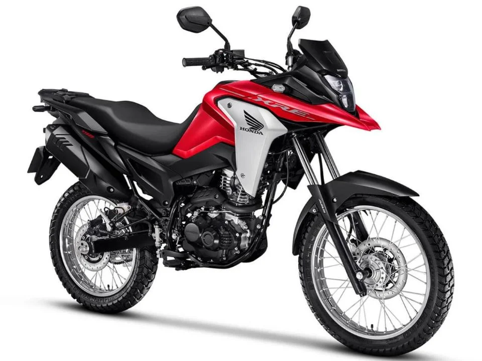 Honda XRE 190 2026 cinza metálico estacionada, exibindo o design atualizado com bico alongado e iluminação LED, destacando sua proposta trail.