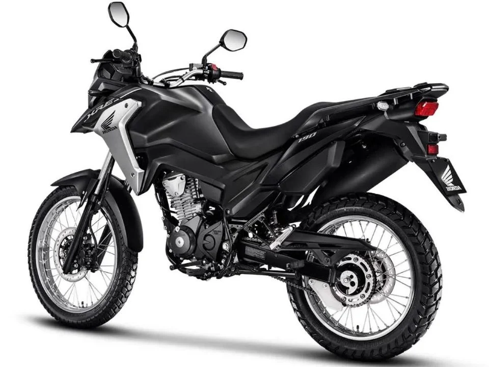 Honda XRE 190 2026 cinza metálico estacionada, exibindo o design atualizado com bico alongado e iluminação LED, destacando sua proposta trail.