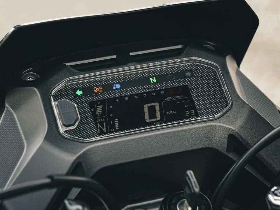 Honda XRE 190 2026 cinza metálico estacionada, exibindo o design atualizado com bico alongado e iluminação LED, destacando sua proposta trail.