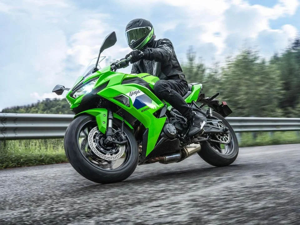 Detalhes da nova Kawasaki Ninja 650 2027 na cor Lime Green, destacando a suspensão dianteira invertida Showa SFF-BP e as pinças de freio de fixação radial.