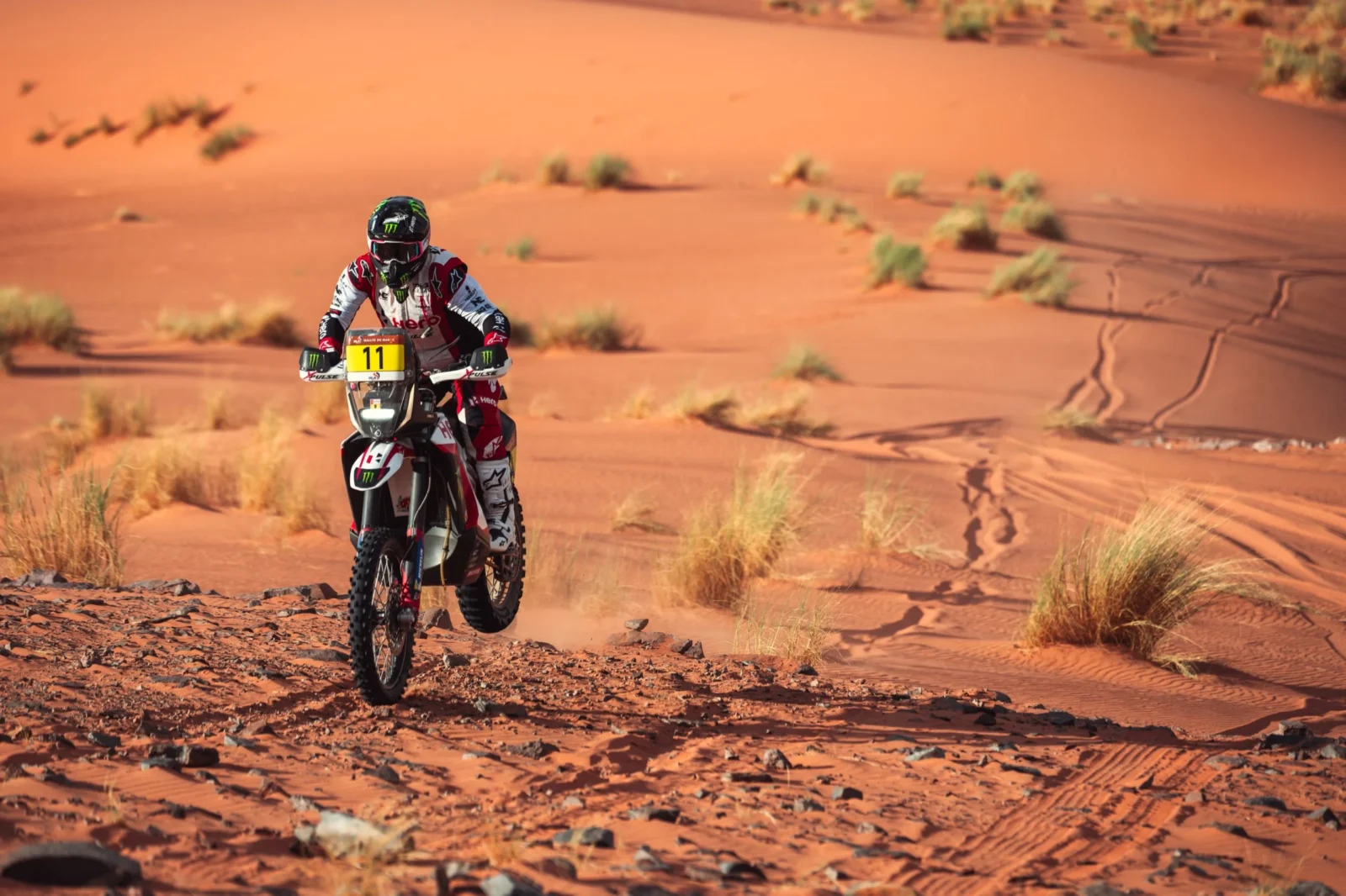 Daniel Sanders pilotando sua moto KTM no Rally de Marrocos 2026 em alta velocidade no deserto, durante a 4ª etapa, com poeira levantando atrás.