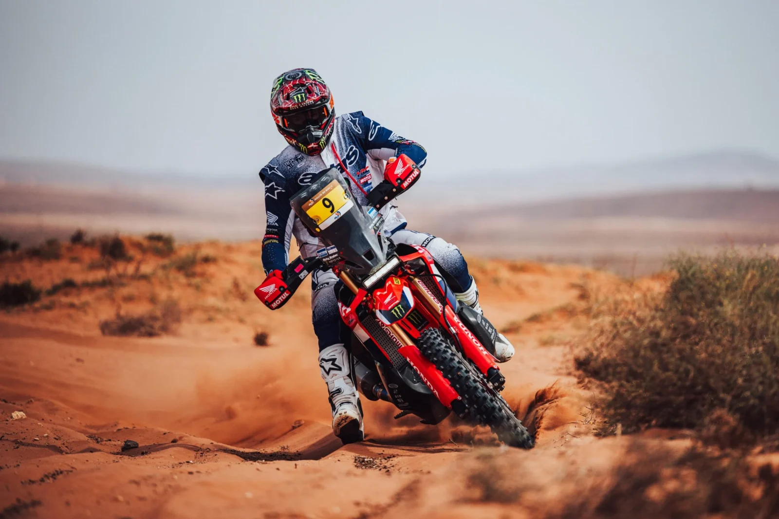Daniel Sanders pilotando sua moto KTM no Rally de Marrocos 2026 em alta velocidade no deserto, durante a 4ª etapa, com poeira levantando atrás.