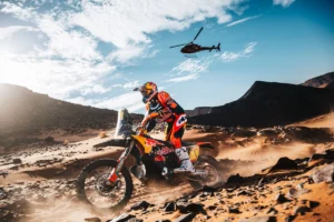 Daniel Sanders pilotando sua moto KTM no Rally de Marrocos 2026 em alta velocidade no deserto, durante a 4ª etapa, com poeira levantando atrás.