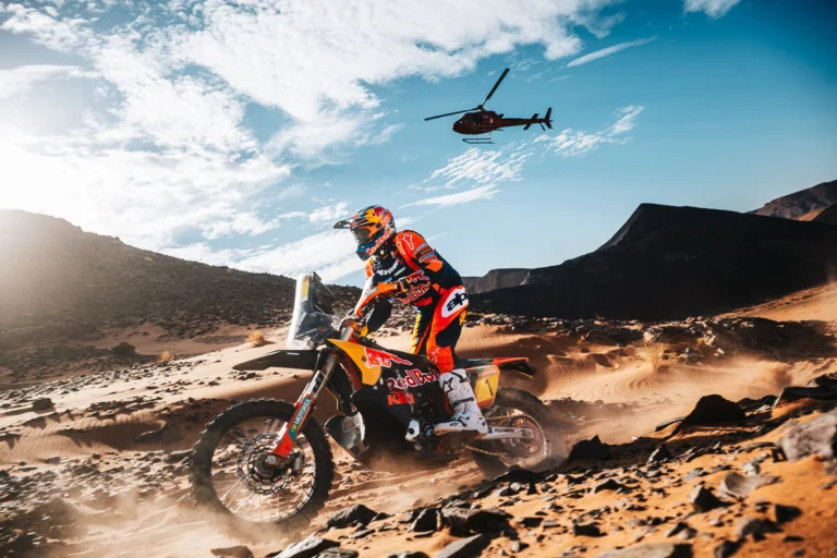 Daniel Sanders pilotando sua moto KTM no Rally de Marrocos 2026 em alta velocidade no deserto, durante a 4ª etapa, com poeira levantando atrás.
