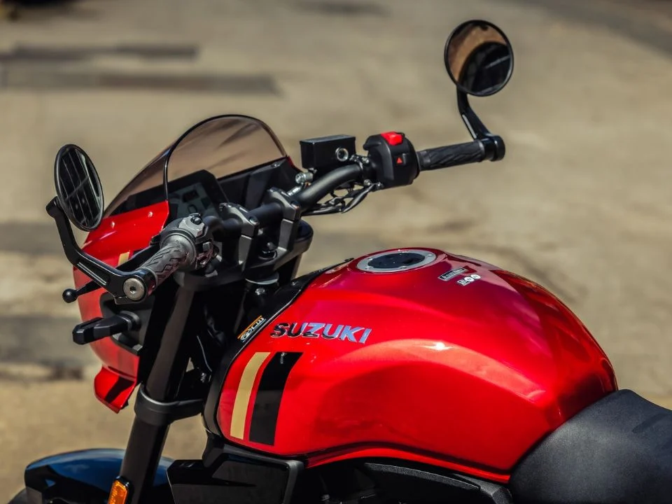 Suzuki GSX-8TT 2027 na nova cor Candy Daring Red, destacando o tanque vermelho com grafismos dourados, rodas douradas e carenagem frontal em estilo retrô.