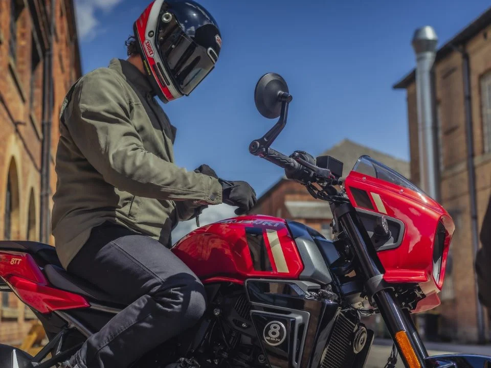 Suzuki GSX-8TT 2027 na nova cor Candy Daring Red, destacando o tanque vermelho com grafismos dourados, rodas douradas e carenagem frontal em estilo retrô.