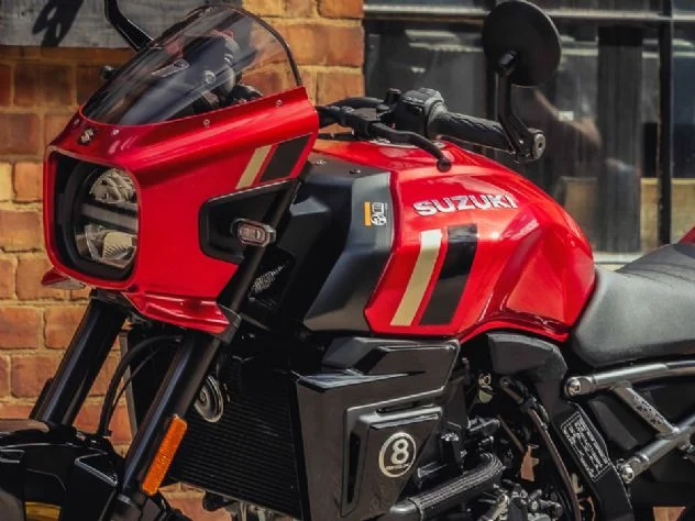 Suzuki GSX-8TT 2027 na nova cor Candy Daring Red, destacando o tanque vermelho com grafismos dourados, rodas douradas e carenagem frontal em estilo retrô.